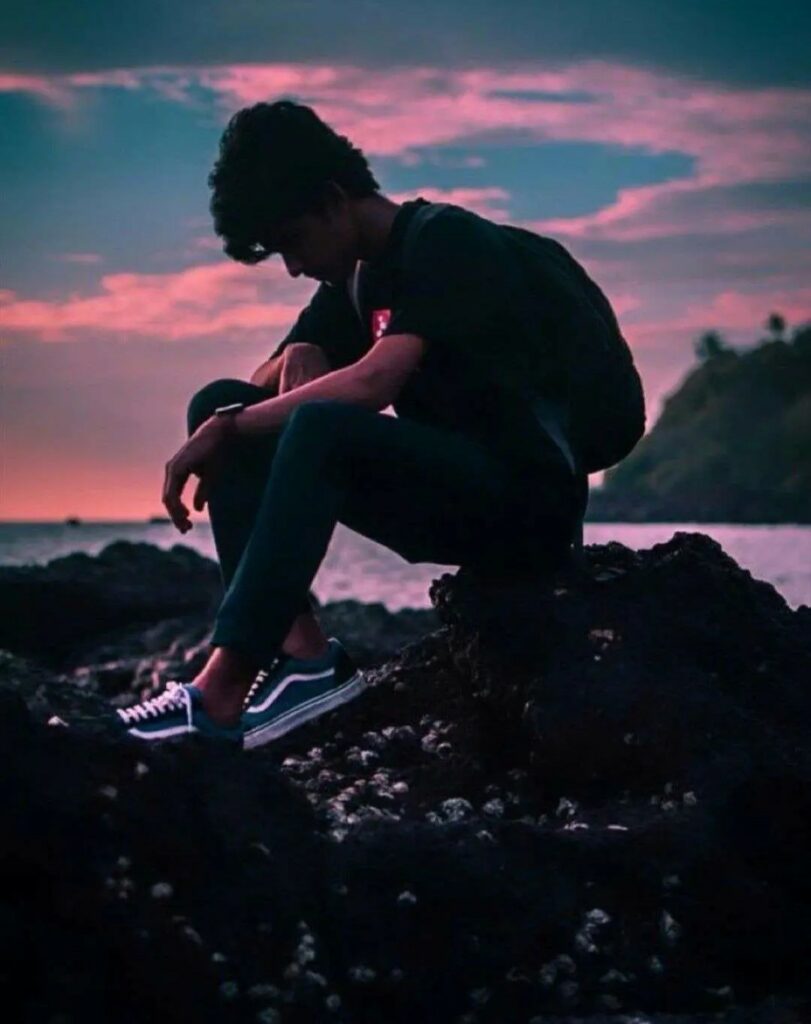 Alone boy sitting seaside 