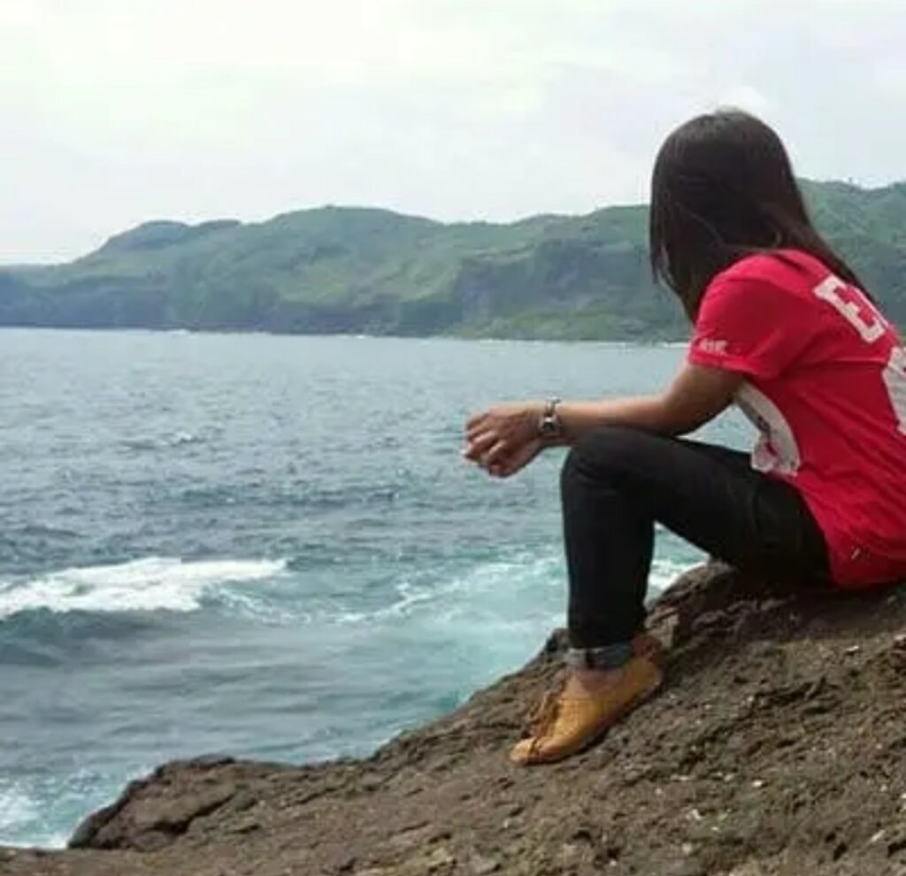 Alone girl sitting on sea side 